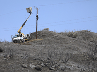 Electricity power engineers at work, in the burned Limassol mountain region near Eptagonia village. Cyprus, Monday, July 5, 2021. The wildfi...