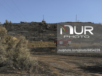 Fire truck rides past the burnt-out area near the village of Eptagonia, in Limassol mountain region. Cyprus, Monday 5 July 2021. The wildfir...