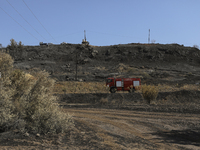 Fire truck rides past the burnt-out area near the village of Eptagonia, in Limassol mountain region. Cyprus, Monday 5 July 2021. The wildfir...