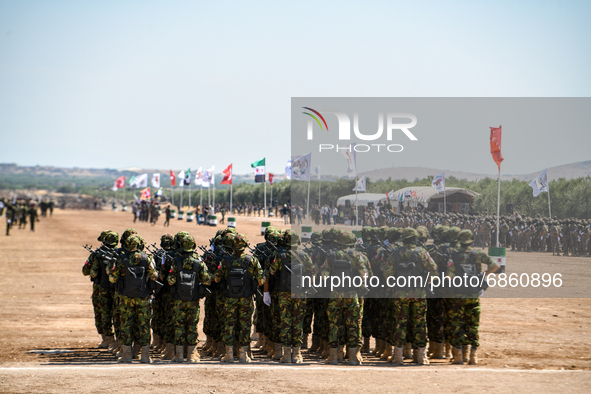 Syrian fighters march in columns, ride dirt bikes and and drive pick-up trucks during a graduation ceremony near the northern city of Afrin...