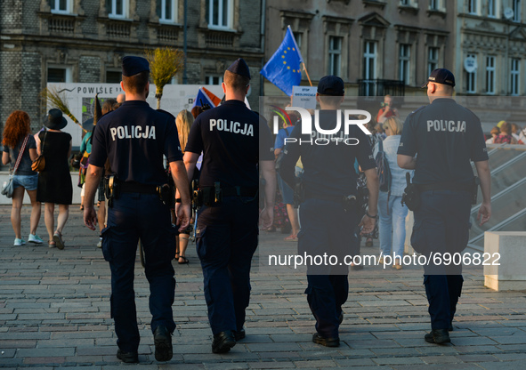 Members of the local Police walk behind KOD (Committee for the Defense of Democracy) activists during the 'March Of Virtuous Women, Witches...