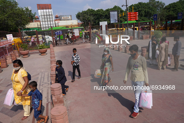 People visit recently developed pedestrian corridor while shipping containers are placed in front of the Red Fort ahead of India's 75th Inde...