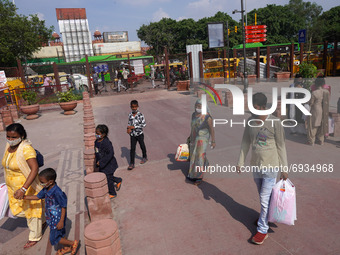 People visit recently developed pedestrian corridor while shipping containers are placed in front of the Red Fort ahead of India's 75th Inde...