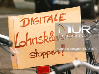 placard with " stop digital wage slavery"  is seen during the riders from Lieferando protest for better working condition in Cologne, German...