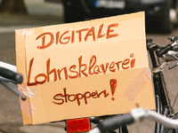 placard with " stop digital wage slavery"  is seen during the riders from Lieferando protest for better working condition in Cologne, German...