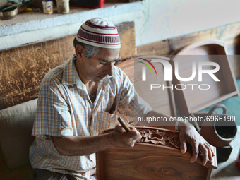 Kashmiri craftsman polishes a hand carved walnut drawer in a small floating workshop on Dal Lake in Srinagar, Kashmir, India, on June 26, 20...