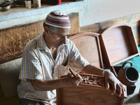 Kashmiri craftsman polishes a hand carved walnut drawer in a small floating workshop on Dal Lake in Srinagar, Kashmir, India, on June 26, 20...