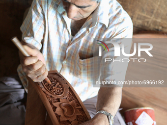 Kashmiri craftsman polishes a hand carved walnut drawer in a small floating workshop on Dal Lake in Srinagar, Kashmir, India, on June 26, 20...