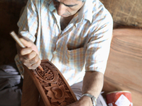 Kashmiri craftsman polishes a hand carved walnut drawer in a small floating workshop on Dal Lake in Srinagar, Kashmir, India, on June 26, 20...