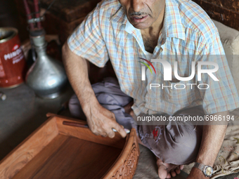 Kashmiri craftsman polishes a hand carved walnut drawer in a small floating workshop on Dal Lake in Srinagar, Kashmir, India, on June 26, 20...