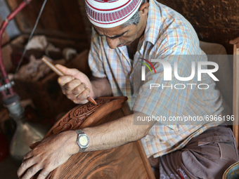 Kashmiri craftsman polishes a hand carved walnut drawer in a small floating workshop on Dal Lake in Srinagar, Kashmir, India, on June 26, 20...