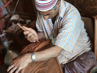 Kashmiri craftsman polishes a hand carved walnut drawer in a small floating workshop on Dal Lake in Srinagar, Kashmir, India, on June 26, 20...