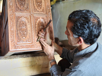 Kashmiri craftsman polishes a hand carved walnut drawer in a small floating workshop on Dal Lake in Srinagar, Kashmir, India, on June 26, 20...