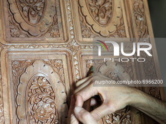 Kashmiri craftsman polishes a hand carved walnut cabinet in a small floating workshop on Dal Lake in Srinagar, Kashmir, India, on June 26, 2...