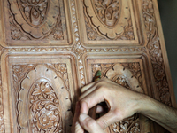 Kashmiri craftsman polishes a hand carved walnut cabinet in a small floating workshop on Dal Lake in Srinagar, Kashmir, India, on June 26, 2...