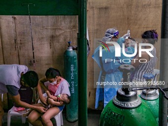 A health worker attempts to conduct a confirmatory swab test to a non-COVID19 patient at the triage area of a hospital in Manila City, Phili...