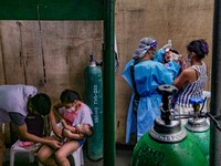 A health worker attempts to conduct a confirmatory swab test to a non-COVID19 patient at the triage area of a hospital in Manila City, Phili...