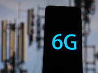 6G sign is seen on the smartphone screen with telecommunication towers in the background in this  illustration photo taken in Krakow, Poland...