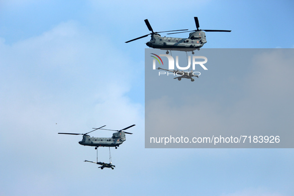 Indian Air Force's Chinook helicopters fly past as they carry Artillery guns during the full dress rehearsal of Air Force Day parade at the...