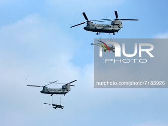 Indian Air Force's Chinook helicopters fly past as they carry Artillery guns during the full dress rehearsal of Air Force Day parade at the...