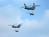 Indian Air Force's Chinook helicopters fly past as they carry Artillery guns during the full dress rehearsal of Air Force Day parade at the...