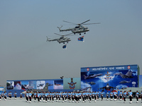 Indian Air Force (IAF) helicopters fly past as soldiers march during Air Force Day parade at the Hindon Air Force Station on the outskirts o...