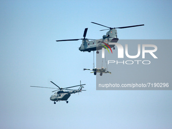 Indian Air Force's (IAF) Chinook helicopter fly past carrying artillery gun along with an Mi-17V-5 helicopter during the 89th Air Force Day...