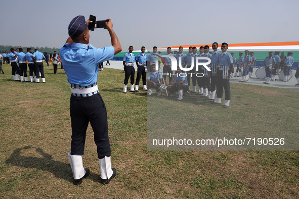 An Indian Air Force (IAF) cadet takes a picture of his teammates during the 89th Air Force Day parade at Hindon Air Force Station on the out...