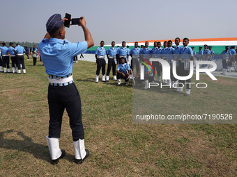 An Indian Air Force (IAF) cadet takes a picture of his teammates during the 89th Air Force Day parade at Hindon Air Force Station on the out...