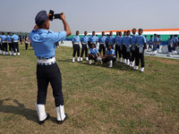 An Indian Air Force (IAF) cadet takes a picture of his teammates during the 89th Air Force Day parade at Hindon Air Force Station on the out...