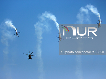 Indian Air Force's (IAF) Sarang helicopters perform aerobatic maneuvers during the 89th Air Force Day parade at Hindon Air Force Station on...