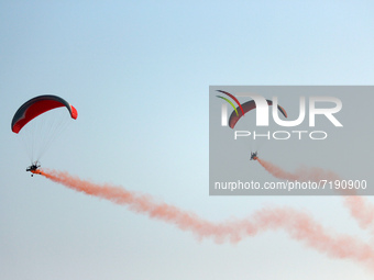 Indian Air Force's (IAF) para motor gliders perform in the air during the 89th Air Force Day parade at Hindon Air Force Station on the outsk...