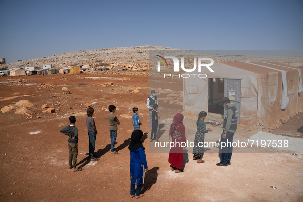 Children attend the first day of school in a refugees camp in the countryside of Idlib. on October 9, 2021. 