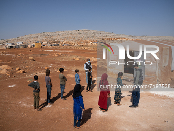 Children attend the first day of school in a refugees camp in the countryside of Idlib. on October 9, 2021. (