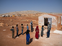 Children attend the first day of school in a refugees camp in the countryside of Idlib. on October 9, 2021. (