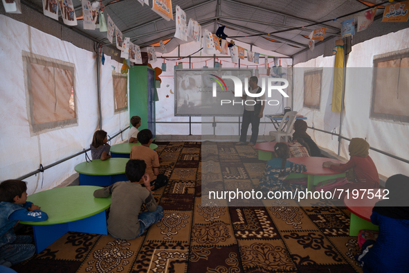 Children attend the first day of school in a refugees camp in the countryside of Idlib. on October 9, 2021. 