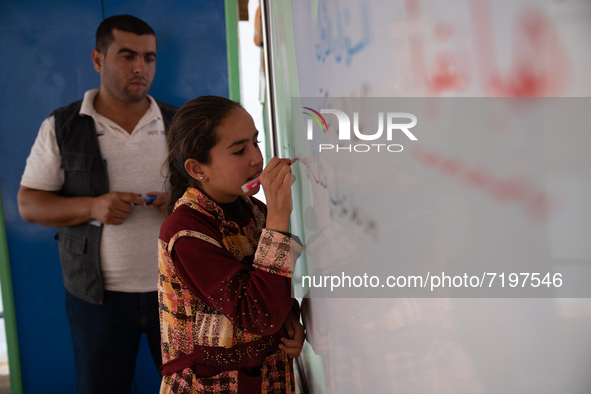 Children attend the first day of school in a refugees camp in the countryside of Idlib. on October 9, 2021. 