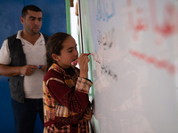 Children attend the first day of school in a refugees camp in the countryside of Idlib. on October 9, 2021. (