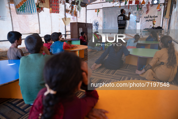 Children attend the first day of school in a refugees camp in the countryside of Idlib. on October 9, 2021. 