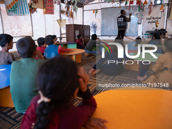 Children attend the first day of school in a refugees camp in the countryside of Idlib. on October 9, 2021. (