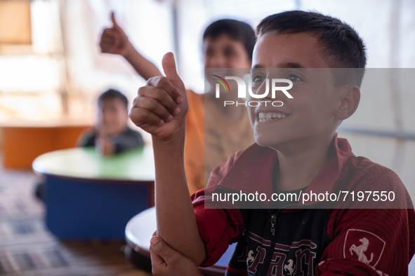 Children attend the first day of school in a refugees camp in the countryside of Idlib. on October 9, 2021. 