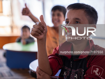 Children attend the first day of school in a refugees camp in the countryside of Idlib. on October 9, 2021. (