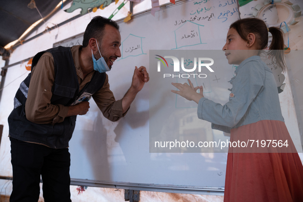 Children attend the first day of school in a refugees camp in the countryside of Idlib. on October 9, 2021. 