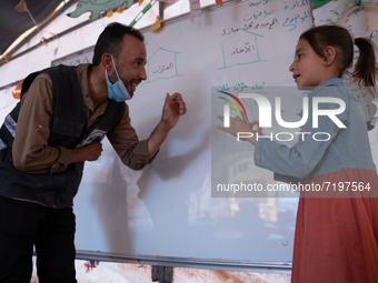 Children attend the first day of school in a refugees camp in the countryside of Idlib. on October 9, 2021. (