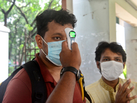 A staff cheek body temperature a students during entry at the residential hall at Dhaka University after reopen their residential halls afte...