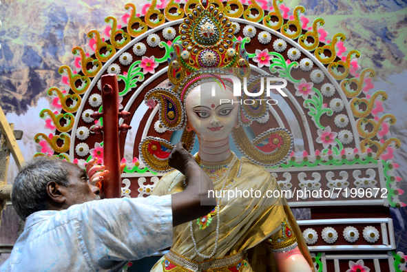 An artist gives final touch to the idol of Hindu Goddess Durga during Durga puja festival in Dhaka, Bangladesh, on October 10, 2021 