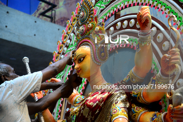 An artist gives final touch to the idol of Hindu Goddess Durga during Durga puja festival in Dhaka, Bangladesh, on October 10, 2021 