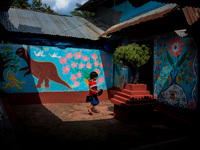A child walks inside a colorful house in alpona village in chapainawabganj, Bangladesh (