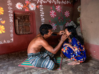 A man helps her daughter to wear a nose pin in Chapainawabganj, Bangladesh, October 9, 2021. (