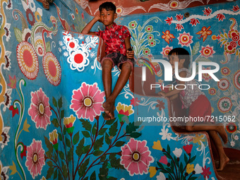 Children play inside a colorfully painted house in alpona village in chapainawabganj, Bangladesh. (